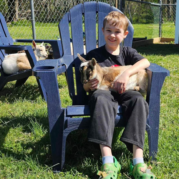 a boy holding a goat